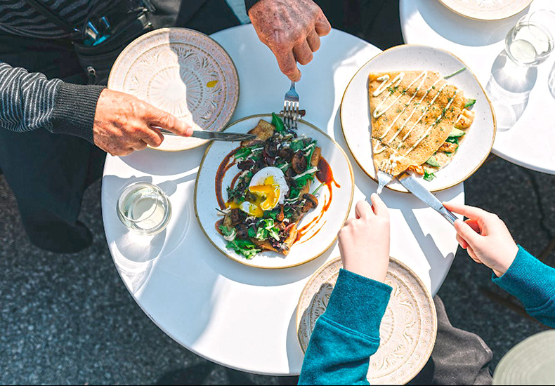 People sharing food at a patio table.